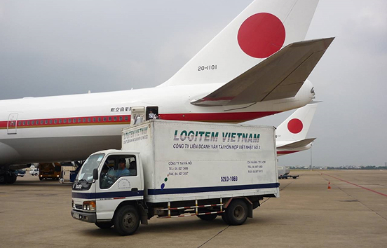 An airplane and a Logitem Vietnam truck at the airport cargo terminal