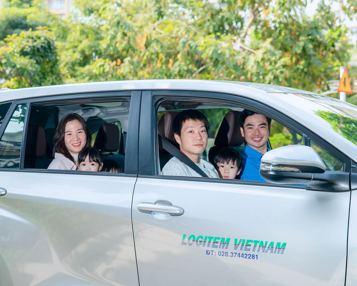 Family getting into a silver minivan with a driver