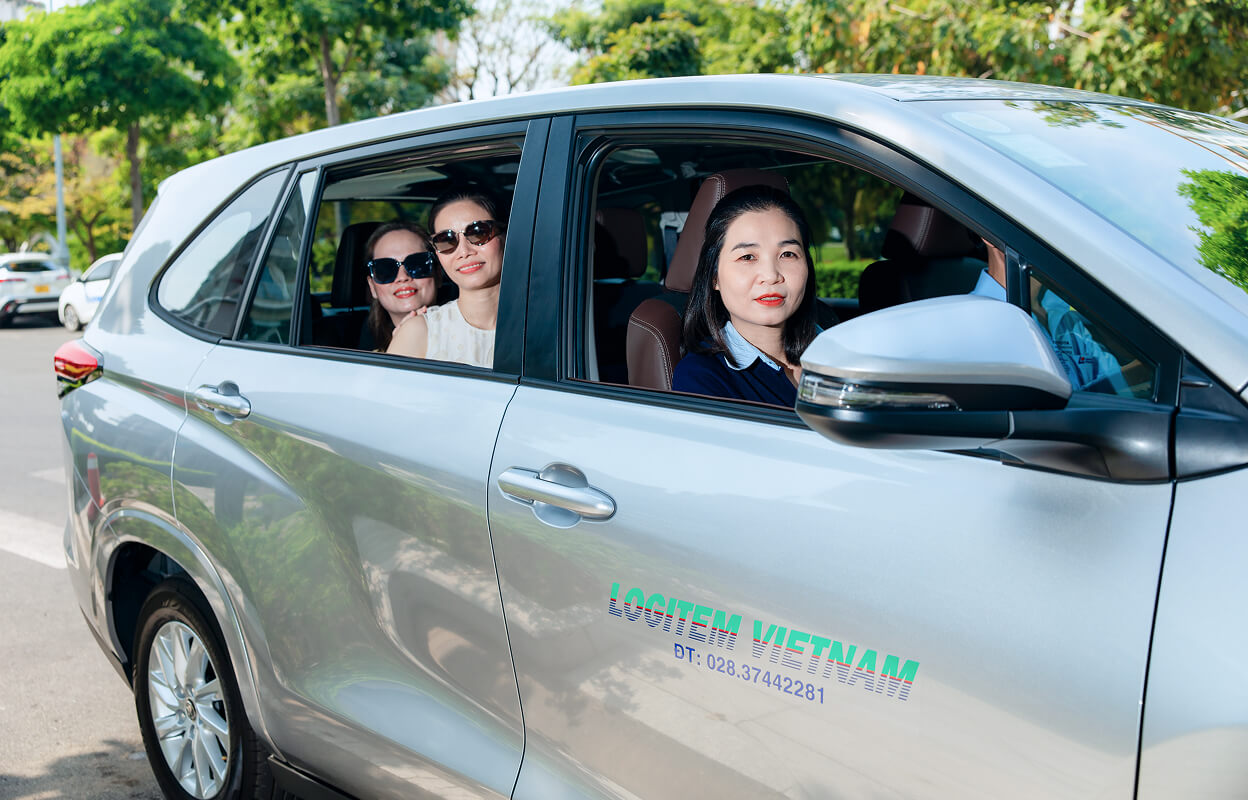 Three female tourists inside a silver car
